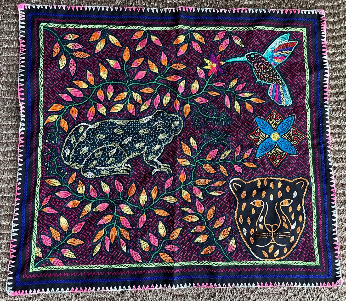 Colorful tapestry with a frog, hummingbird, and panther design on a purple background.