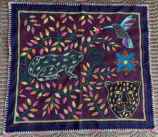 Colorful tapestry with a frog, hummingbird, and panther design on a purple background.