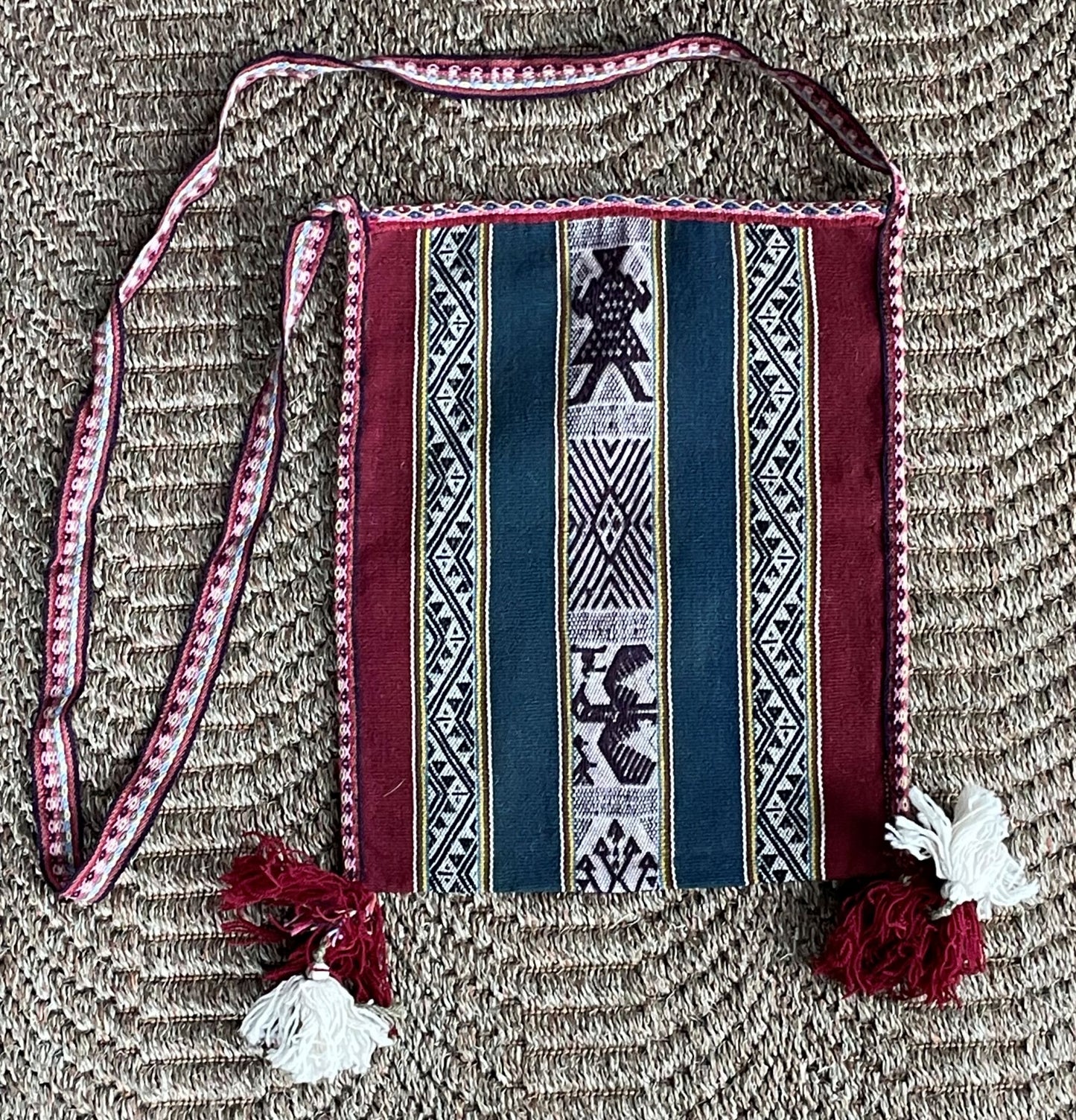 Traditional patterned bag with a strap on a textured surface