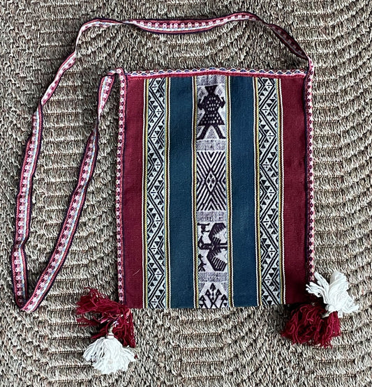 Traditional patterned bag with a strap on a textured surface